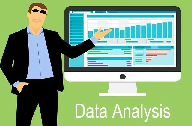 A person in a suit stands next to a large computer monitor displaying various data visualizations, including bar charts and graphs, with the text "Data Analysis" below.